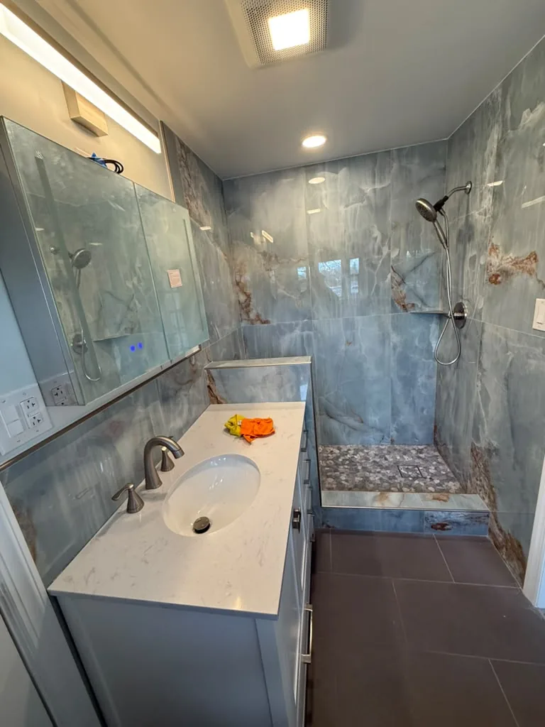 Finished bathroom with stone slab shower and vanity