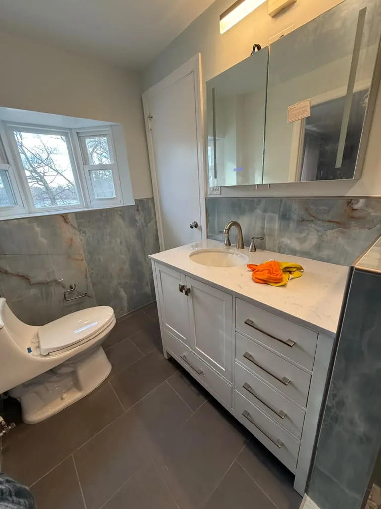 Bathroom with white vanity and stone slab shower