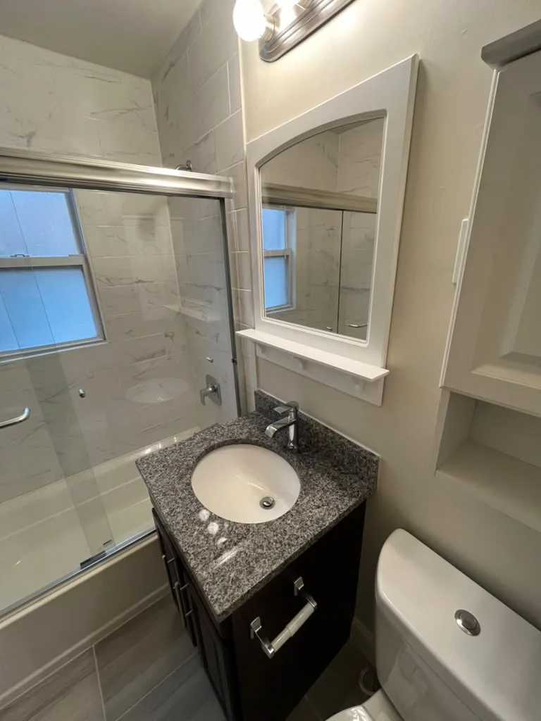 Glass enclosure with dark vanity and granite top