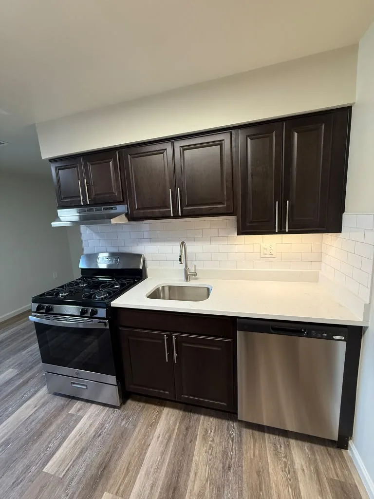 Espresso kitchen with white countertops and stainless dishwasher