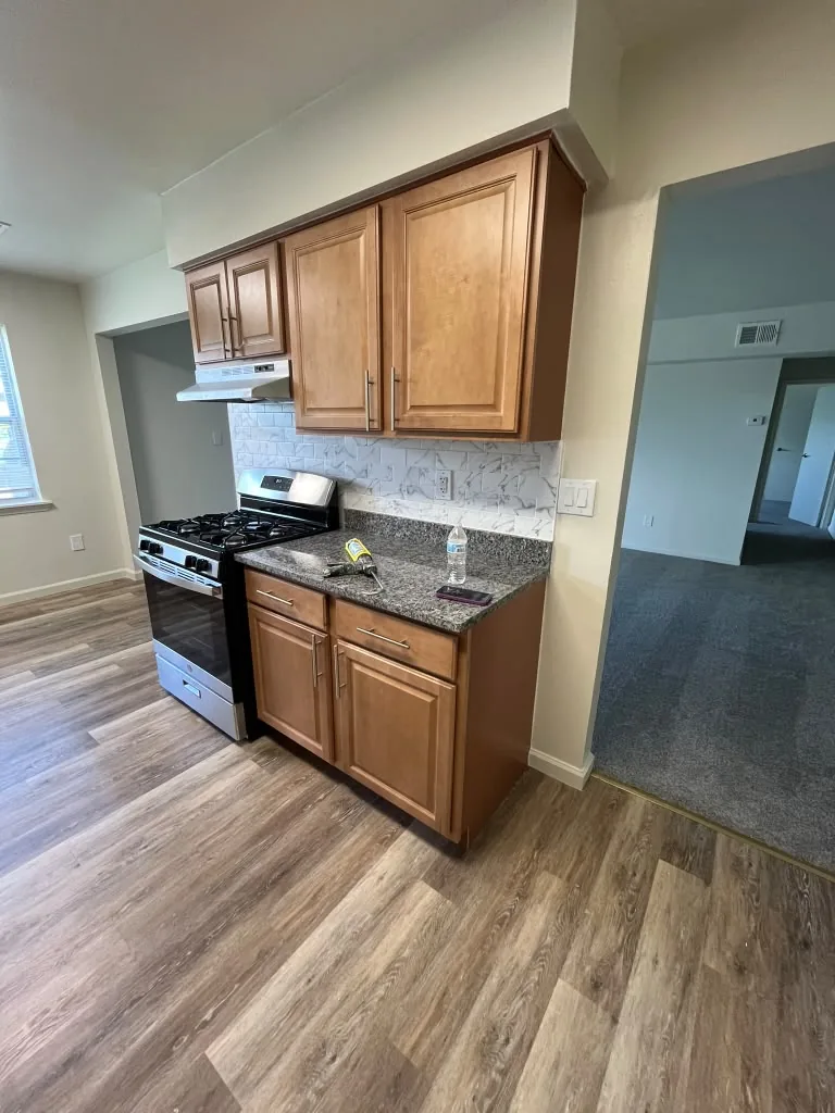 Kitchen with wood cabinets, granite counters and gas range
