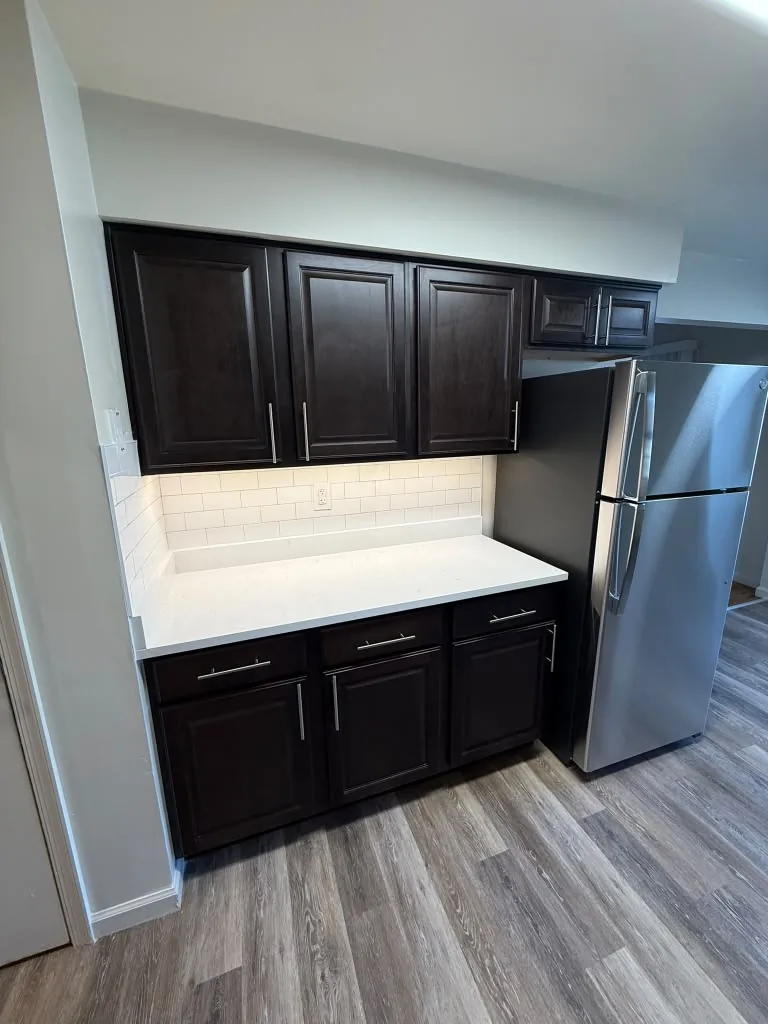 Kitchen with dark cabinets and white countertops
